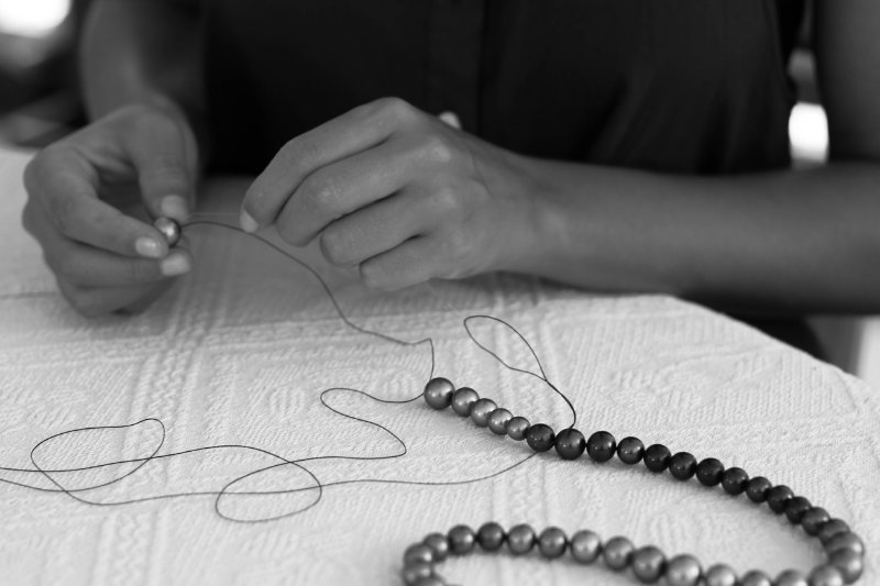Mains expertes fabriquant un collier